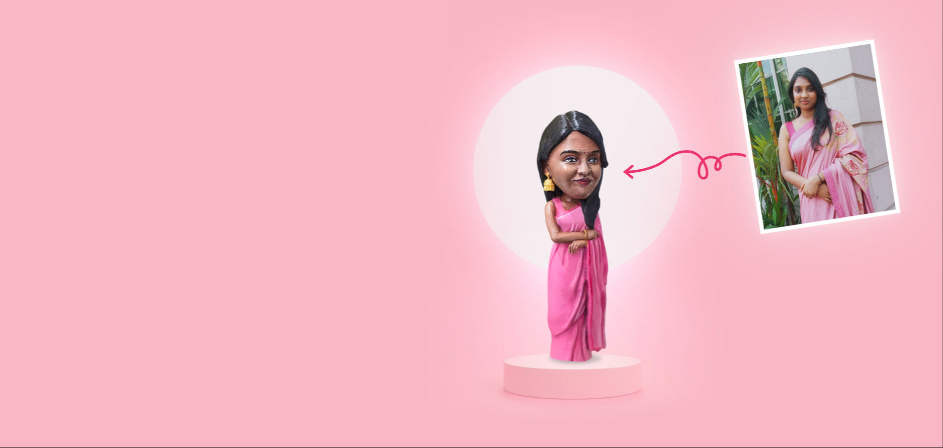 Bobblehead of a woman in a pink saree with an inset photo on a pink background